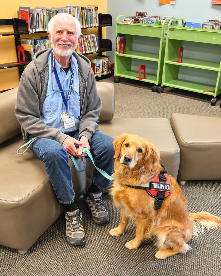 David Smith seated next to golden retriever.